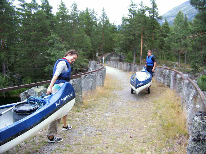 Crossing the old Mæle bridge with our canoes